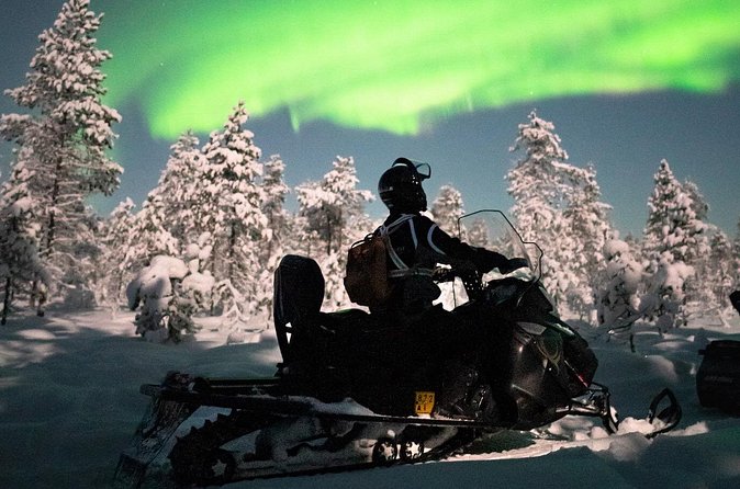 Northern lights safari by snowmobile - Riding through the dark Finnish countryside